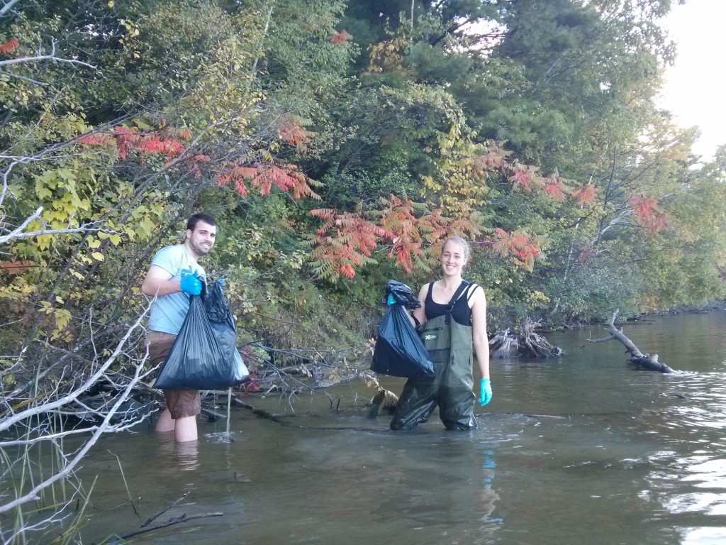 Mike Lawrence and Laura Elmer get wet and dirty cleaning the Rideau shoreline